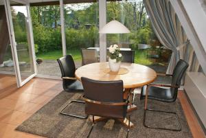 a dining room with a wooden table and black chairs at Zeltdachhaus mit TV im Schlafzimme in Damp