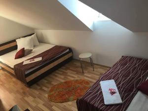 a small room with two beds and a stool at Vila Denis in Costinesti