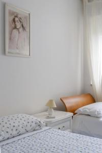 Un dormitorio con 2 camas y un escritorio con una foto en la pared. en °la casetta d'Amare°, en Torre Suda