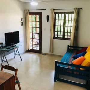 ein Wohnzimmer mit einem Sofa und einem TV in der Unterkunft Apartamento em Lencois - Bahia No 106 in Lençóis
