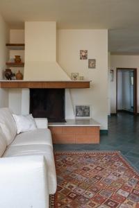 sala de estar con sofá blanco y chimenea en °la casetta d'Amare°, en Torre Suda