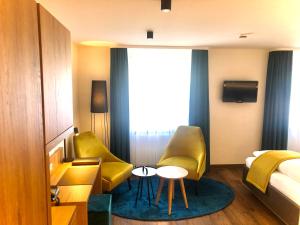 a hotel room with two yellow chairs and a bed at Hotel Restaurant Lamm in Stein