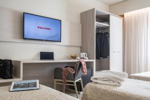 a hotel room with a television on a wall at Alfa Fiera Hotel in Vicenza