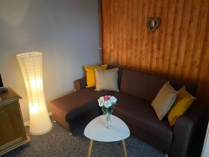 ein Wohnzimmer mit einem Sofa und einem Tisch mit einer Blumenvase in der Unterkunft Penzión Exclusive in Trenčín