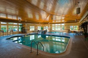uma grande piscina interior num edifício com tectos em madeira em Holiday Inn Express Hotel & Suites Chicago West Roselle, an IHG Hotel em Roselle