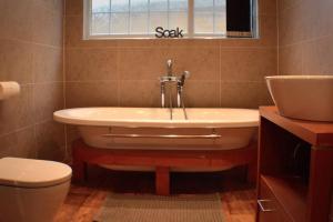 a bathroom with a tub and a toilet and a sink at The Den Studio Apartment - Withernsea in Withernsea