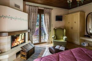 a bedroom with a fireplace and a green chair at Naiades Guesthouse in Klávsion