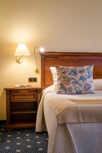 a hotel room with a bed with a lamp on a table at Casa León Royal Retreat in Maspalomas