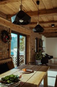 a kitchen with a wooden table and a dining room at Dom Mazurski Tumiany 3 B in Tumiany