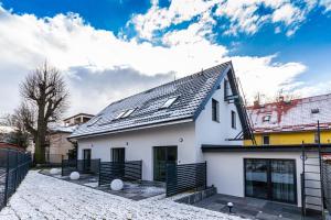a white house with a black roof at Apartamenty Caminski Deluxe in Kudowa-Zdrój