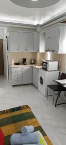 a kitchen with white cabinets and a washer and dryer at SeaSide Apartment Rio in Rio