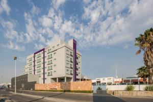 - un grand bâtiment blanc dans une rue bordée de palmiers dans l'établissement HS HOTSSON Smart León Centro Max, à León