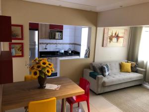 a living room with a table and a couch at Flat Blumenau Vila Nova in Blumenau