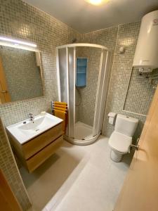 uma casa de banho com um chuveiro, um WC e um lavatório. em Apartamento con piscina a 350 metros de la playa em Vinarós