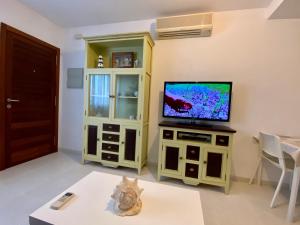 ein Wohnzimmer mit einem TV auf einem Schrank in der Unterkunft Apartamento con piscina a 350 metros de la playa in Vinarós