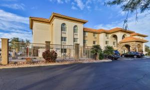 a building with a fence in front of a parking lot at Wingate by Wyndham Chandler Phoenix in Chandler