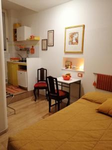 Il comprend une chambre avec une table et deux chaises ainsi qu'une cuisine. dans l'établissement Rizzi, elegante monolocale in Centro Storico, à Venise