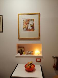 - un bol de fruits sur une table avec une lumière dans l'établissement Rizzi, elegante monolocale in Centro Storico, à Venise