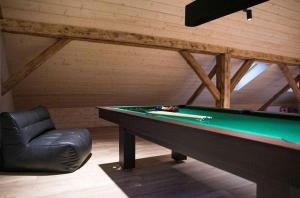 a billiard table and a leather chair in a room at Dom Mazurski Tumiany 3 B in Tumiany