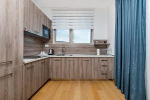 eine Küche mit Holzschränken und einem blauen Vorhang in der Unterkunft Apartments LORA in Apart-hotel in Budva