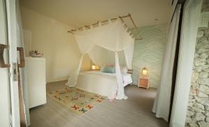 a bedroom with a white bed with a canopy at The Chillhouse Canggu by BVR Bali Holiday Rentals in Canggu