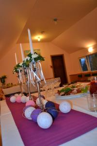 una mesa con velas y platos de comida. en Guest House Pilsētnieki, en Slampe