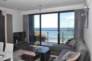 a living room with a couch and a view of the ocean at Ostseeblick Rewal in Rewal