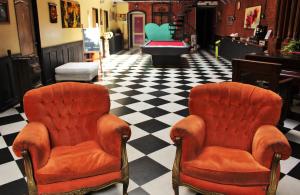 two orange chairs in a room with a checkered floor at DEL900 Hostel Boutique in Buenos Aires