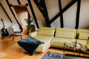 sala de estar con sofá y guitarra en Fachwerkhäuschen, en Enkirch