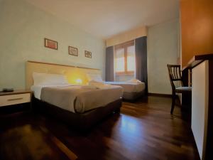 una habitación de hotel con 2 camas y una silla en Sole della Franciacorta - Hotel & Restaurant, en Capriolo