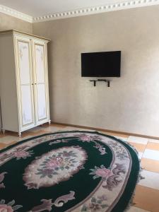 un soggiorno con tappeto e TV a schermo piatto di Mini Hotel Business class a Kryvyj Rih
