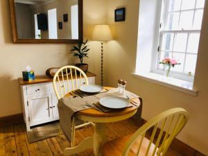a dining room with a table and chairs and a mirror at FYNE VIEW APARTMENT in Inveraray