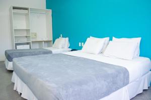 a bedroom with a white bed and white pillows at Bahia Sol e Mar in Salvador