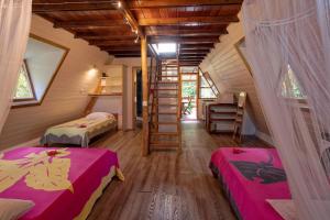 a room with two beds and a staircase in a house at Pension Les Trois Cascades in Uturoa