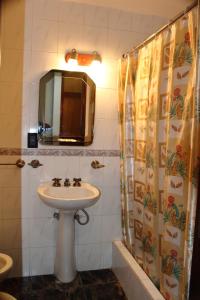 y baño con lavabo y espejo. en Hotel Los Cuartos en Tafí del Valle
