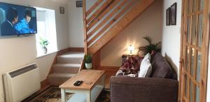 a living room with a chair and a table and stairs at FYNE VIEW APARTMENT in Inveraray