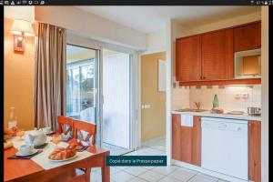 a kitchen with a table and a dining room at Appartement près lac et océan in Carcans