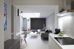 a kitchen and a living room with a couch at Temple Apartments Belgrade in Belgrade