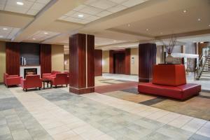 a lobby of a hotel with red chairs and stairs at Viscount Gort Hotel, Banquet & Conference Centre in Winnipeg