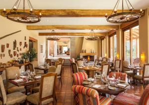 a restaurant with tables and chairs and windows at Inkaterra Hacienda Urubamba in Urubamba