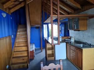 una cocina con una escalera que conduce a un loft en Costa Soñada Apart Hotel en Santa Clara del Mar