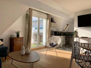 uma sala de estar com um sofá, uma mesa e cadeiras em LA BAULE - COUP DE CŒUR – T3 - Tout à Pied em La Baule