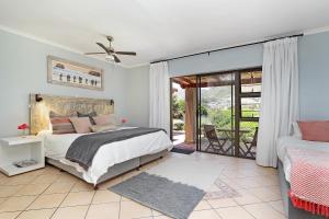 a bedroom with a bed and a balcony at The Salt House in Hout Bay