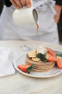 une personne verse du sirop sur une assiette de nourriture dans l'établissement Ecocirer Healthy Stay, à Sóller