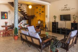 a living room with chairs and a television and stairs at Flying Dog Hostel Iquitos in Iquitos