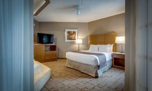 Кровать или кровати в номере Monte Carlo Inn Vaughan Suites