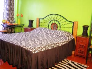 a bedroom with a bed and a green wall at Khweza Bed and Breakfast in Nairobi