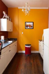 a kitchen with orange walls and a red trash can at Blue60 Marigny Inn in New Orleans