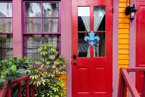 una puerta roja delante de una casa colorida en The Blue60 Marigny Inn, en Nueva Orleans