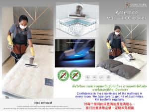 a man vacuum cleaning a mattress with a vacuum cleaner at Gems Park Don Mueang Airport and BTS in Bangkok